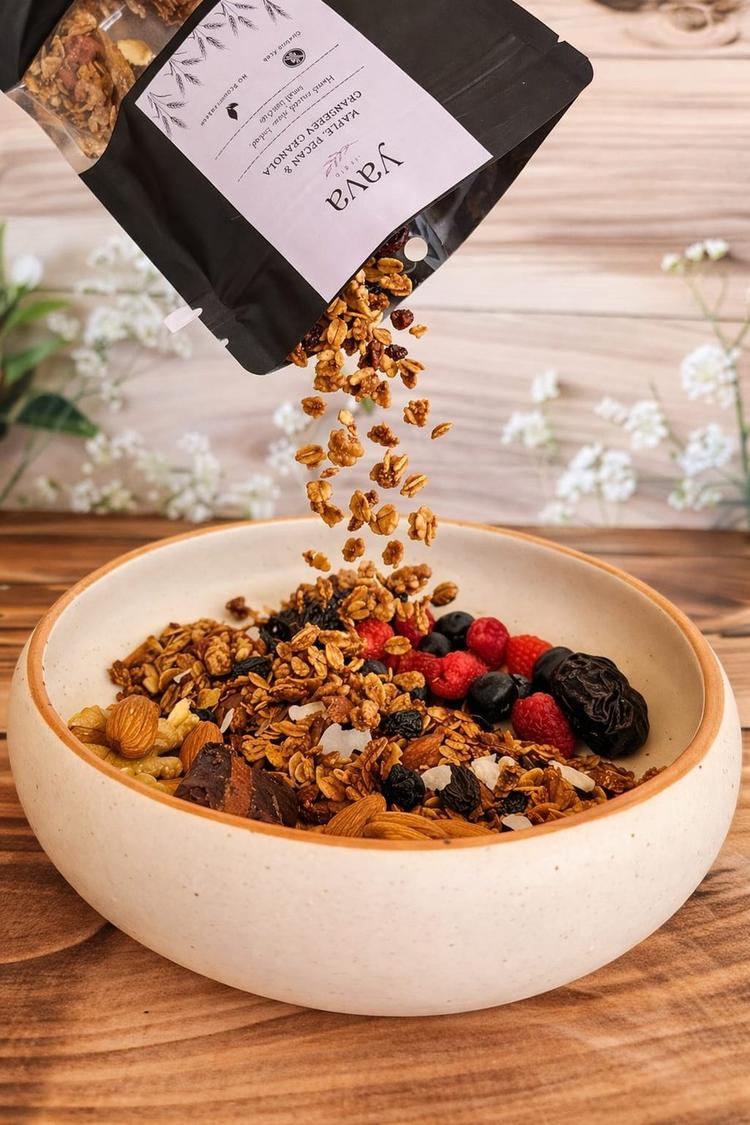 Yava Maple Pecan Cranberry Granola being poured into bowl